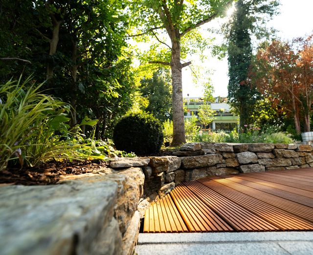 Natural stone retaining wall beside hardwood decking
