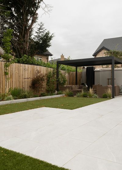 Light-grey porcelain patio with a black pergola