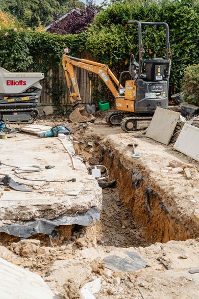 Mini digger and tracked dumper excavating footings in a back garden